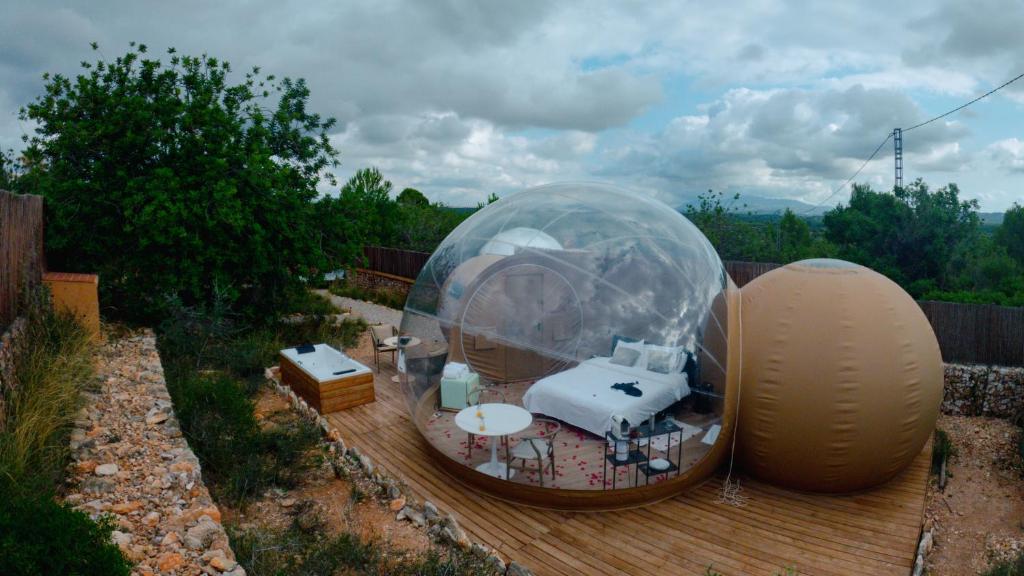 Alojamiento burbuja romántico con cama doble y jacuzzi exterior en entorno natural